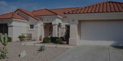 A white Scottsdale home for sale with clay roof tiles and  desert landscaping.